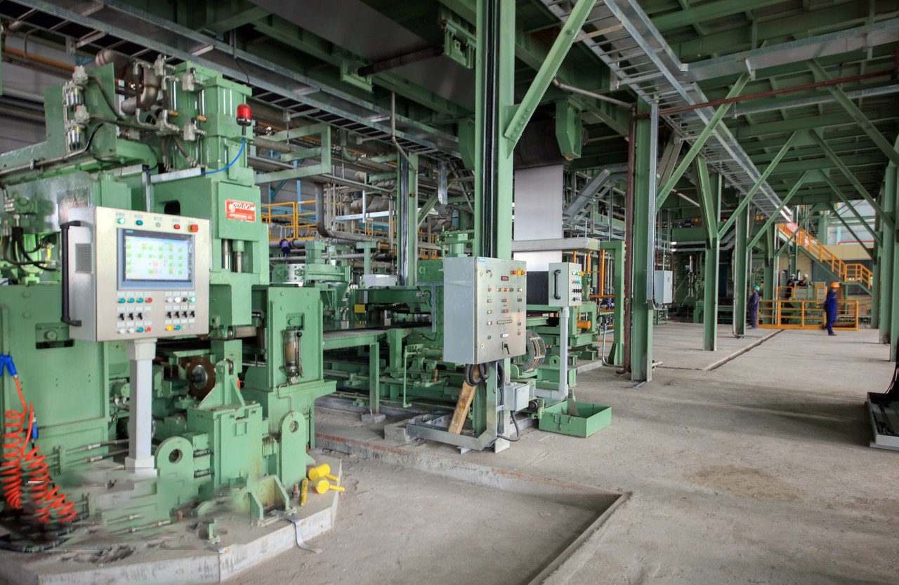 Wide view of MFY production workshop with stainless steel coils, industrial rolling machines, and team operations under safety protocols